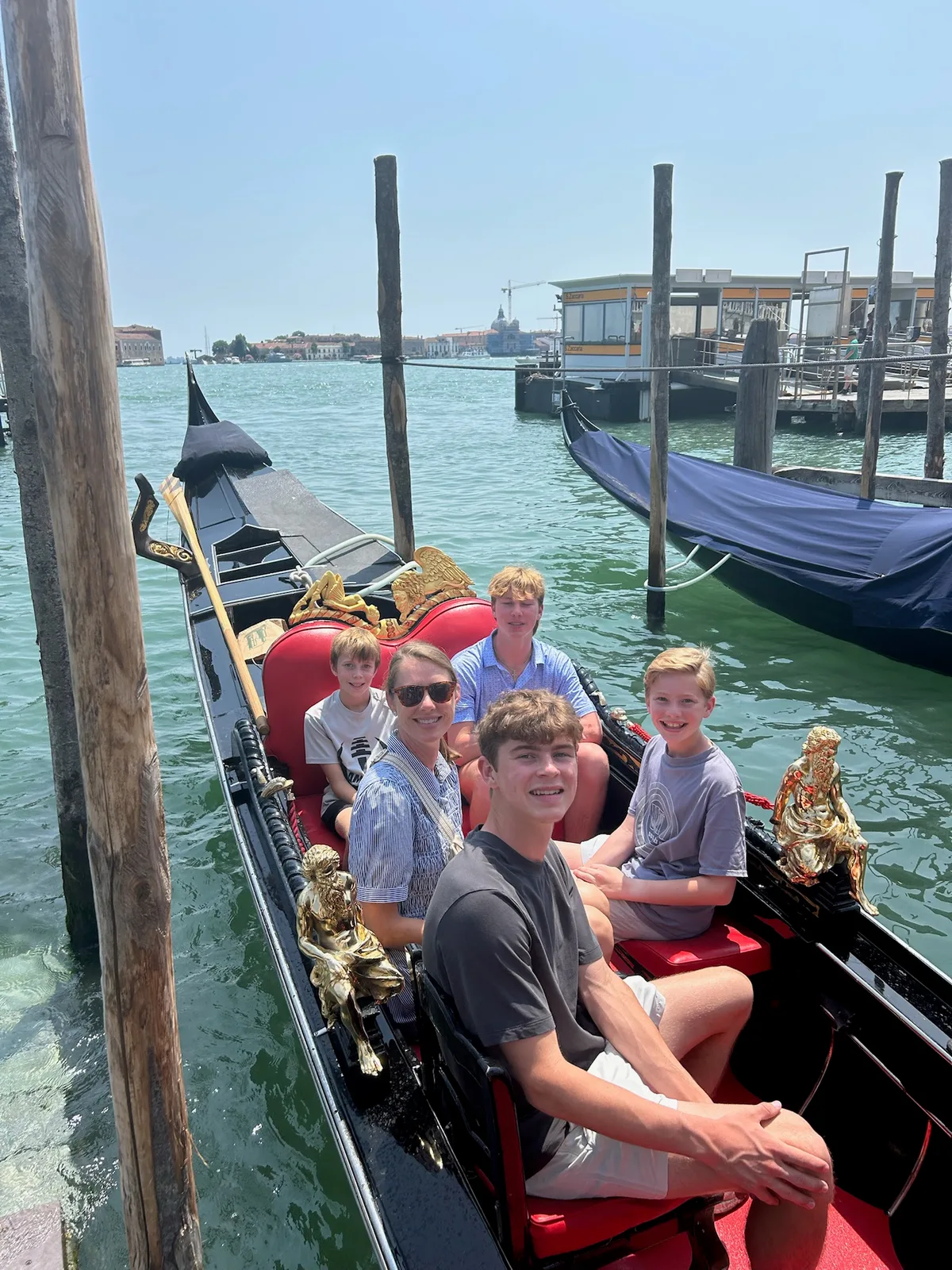 The family seated together in a gondola on a Venice canal tour