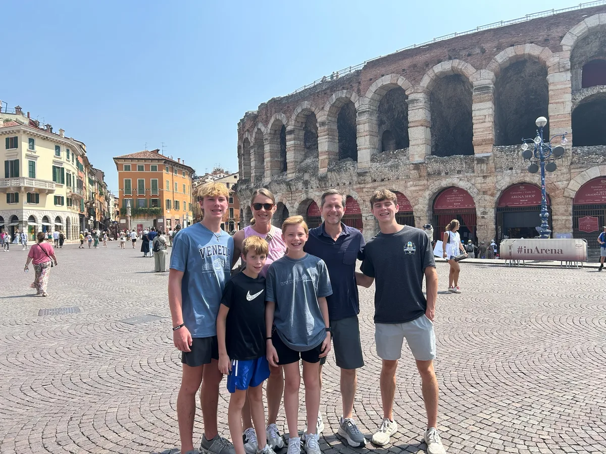 The family in front of the stone arches of the Verona Arena