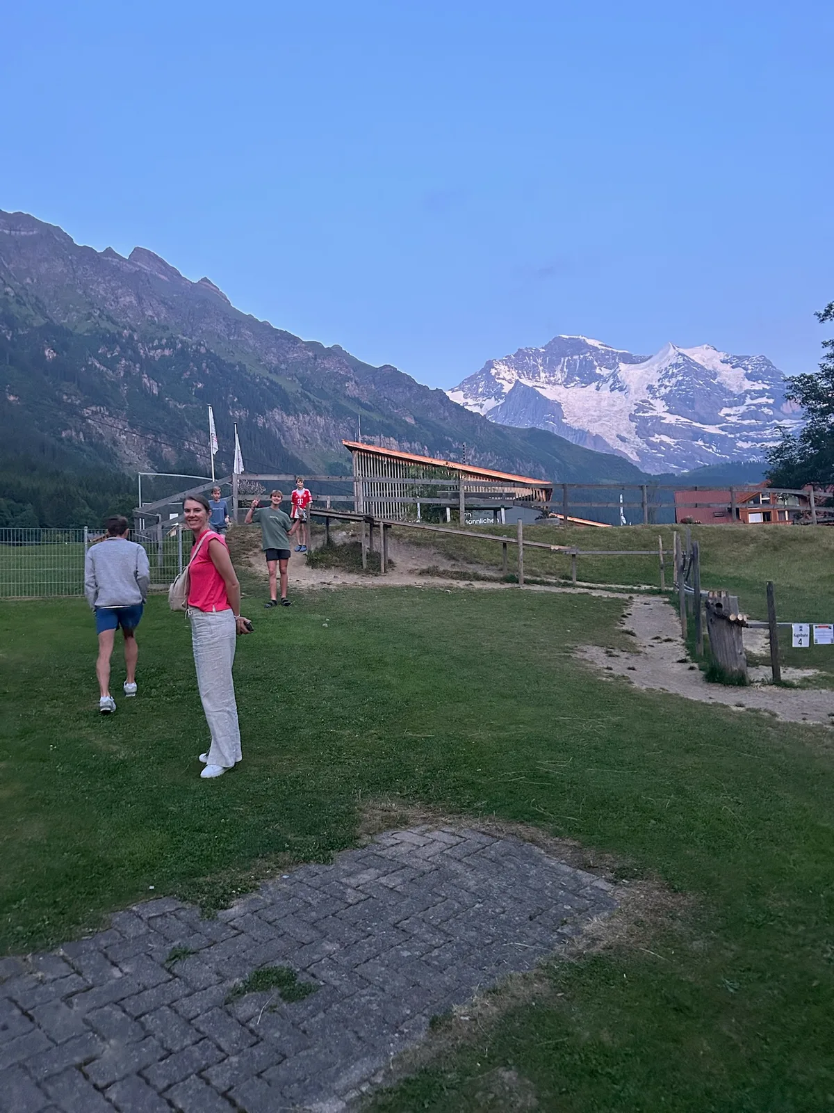 Family walking through an Alpine village with mountains in the distance