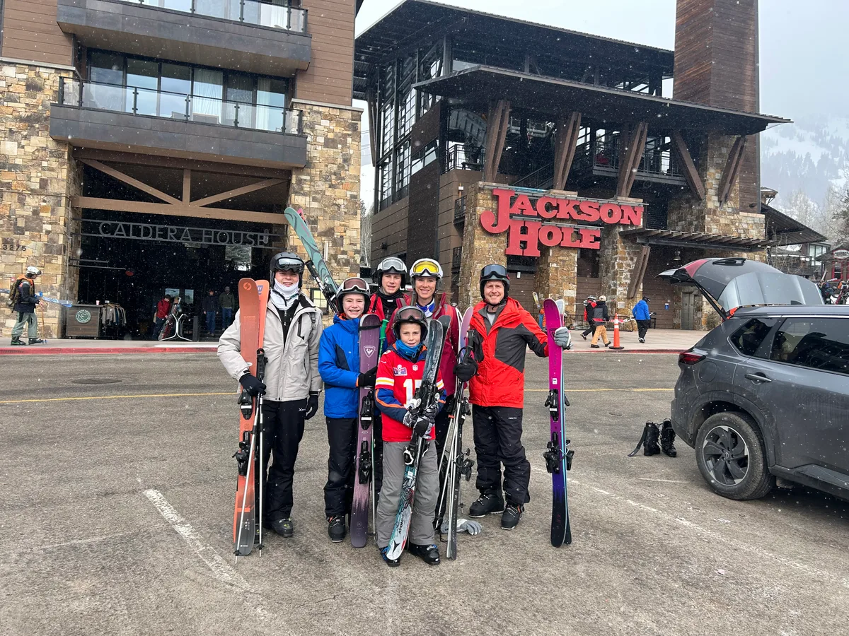 The family with skis beneath the Jackson Hole sign